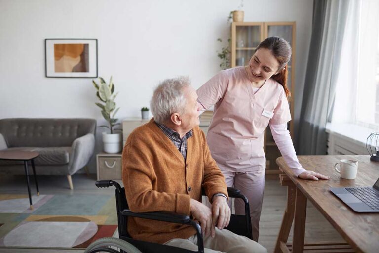 Caregiver reviewing a medication chart beside labeled pill containers in a resident’s apartment